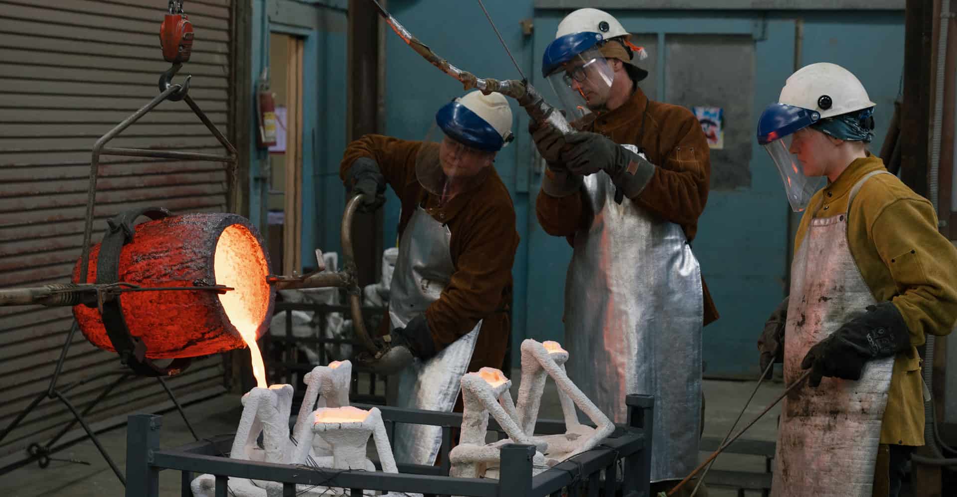 Volunteer pouring molten bronze at Odiyan foundry for large-scale sacred statue