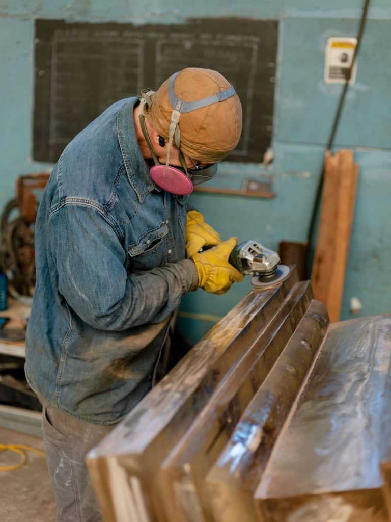 Foundry volunteer grinding bronze stupa, Odiyan Buddhist retreat